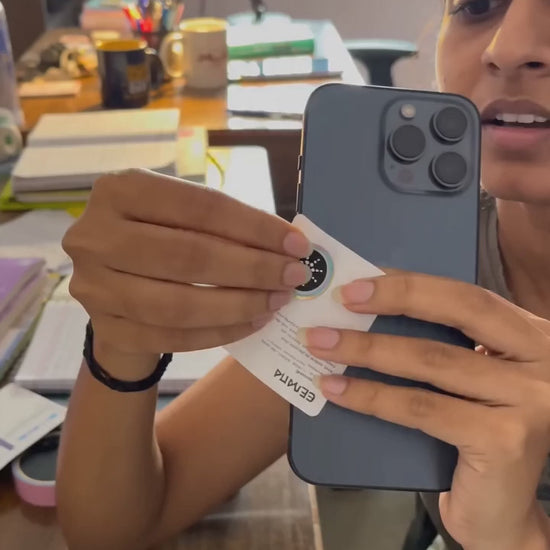 Customer applying a QuietField EMF chip to a phone